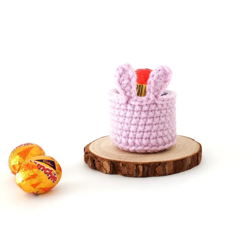 Crochet purple mini bunny basket with a creme egg inside.