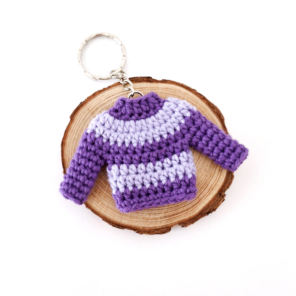 Crochet stripey purple sweater keychain.