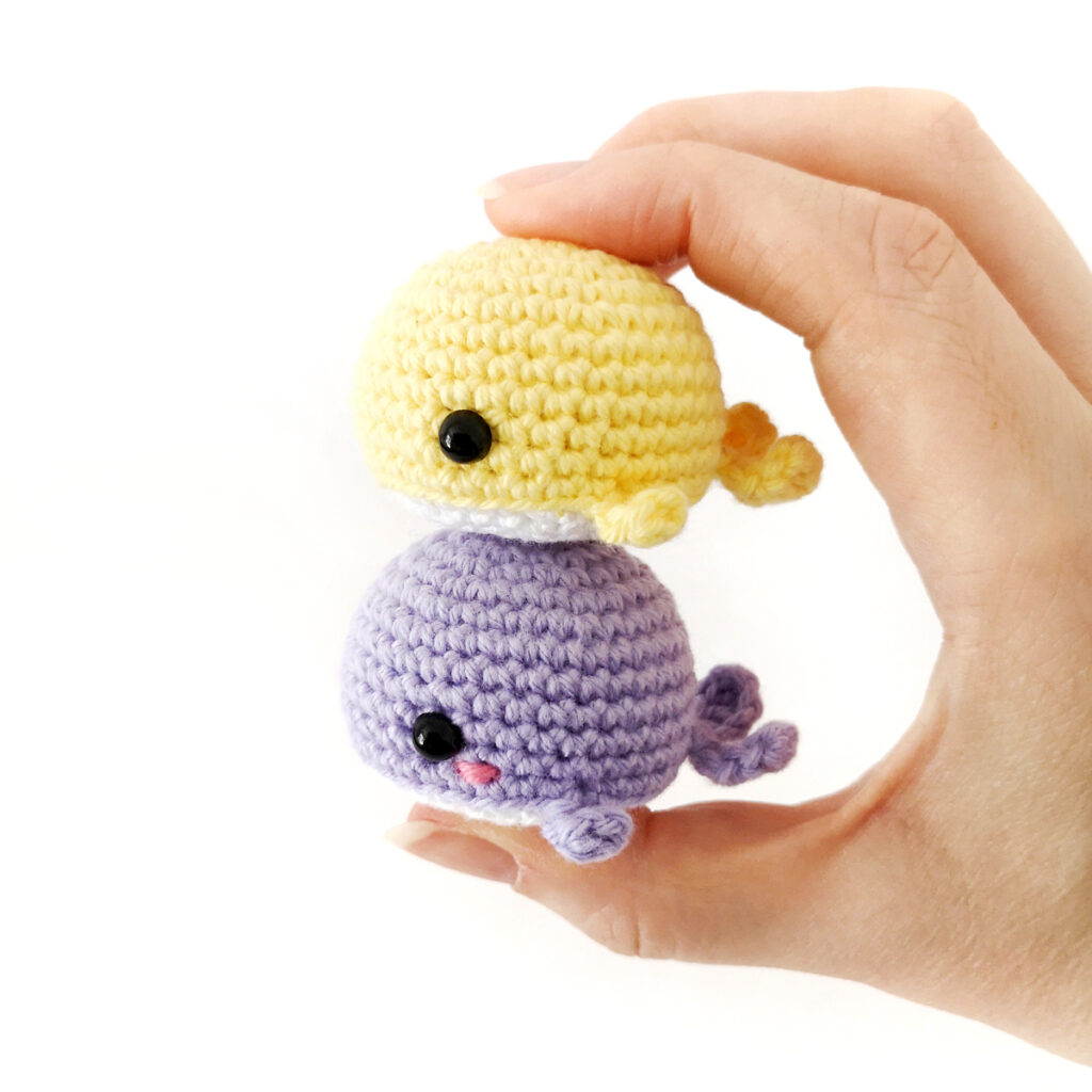 Two crochet whales held in a stack.