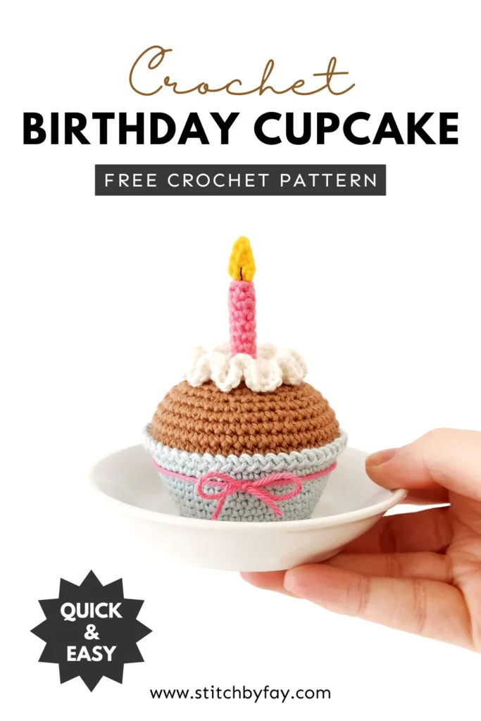 Pinterest image showing a crochet cupcake with white wavy icing,  a pink candle with a yellow flame and a light blue cupcake liner tied with a pink bow. The cupcake is sitting on a small white dish held in one hand. Text overlay reads: "Crochet birthday cupcake, free crochet pattern, www.stitchbyfay.com" with "quick & easy" in a starburst.