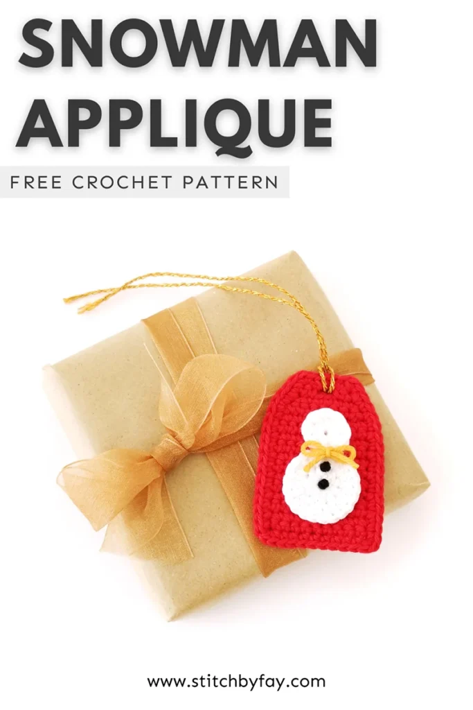 Pinterest image showing a crochet snowman applique with yellow bow and small black French knots for buttons, attached to a red crochet gift tag with gold tie, lying on top of a brown paper wrapped gift. Text overlay reads: "Snowman applique, free crochet pattern, www.stitchbyfay.com".