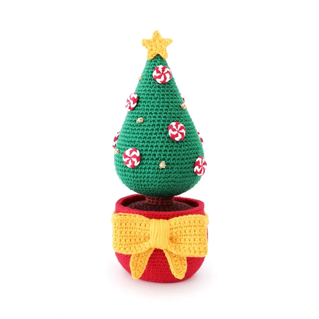 Crochet Christmas tree featuring a red pot, large yellow crochet bow and star, decorated with red and white crocheted peppermints and gold French knots against a white background.